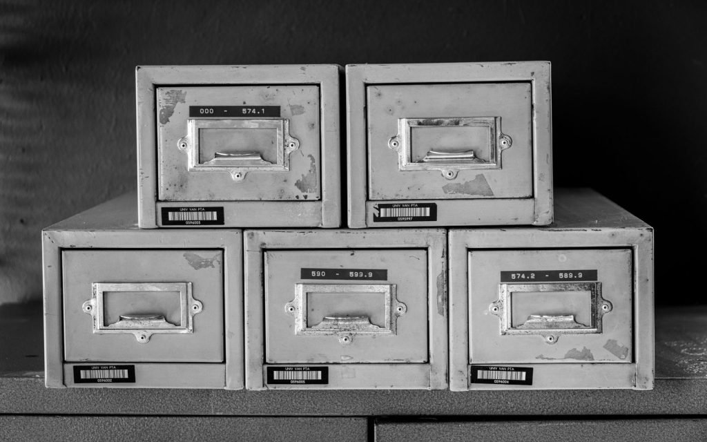 A wall of labelled filing cabinet drawers, one per record type
