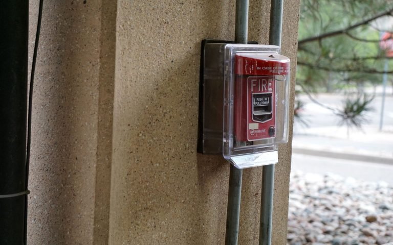 A fire alarm pull station on a wall, waiting to be needed